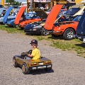 Child driving a toy car.